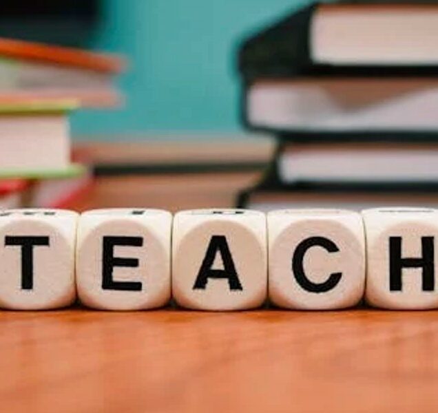 Five small, wooden blocks bearing the letters T, E, A, C and H spell out the word "teach."